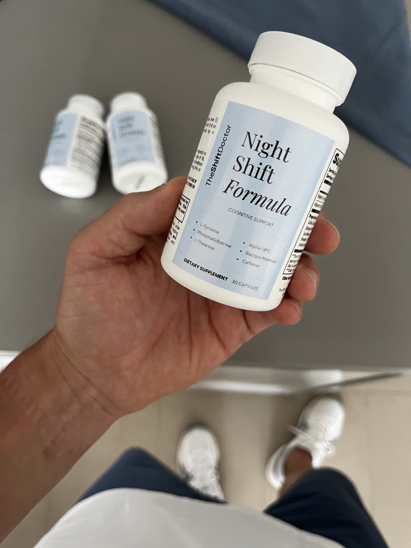 Hand holding a bottle of TheShiftDoctor Night Shift Formula